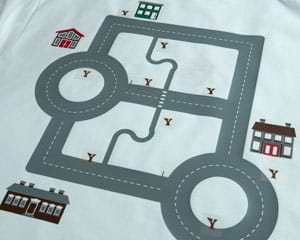 The car shirt in the middle of being pressed- many houses are almost finished and the trees need tops