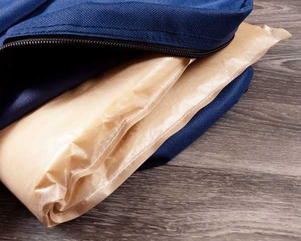 Showing the inside of the blue backpack after a pressing pillow has been placed inside