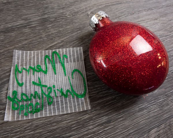The cut sticker vinyl on the transfer material with the glitter ornament