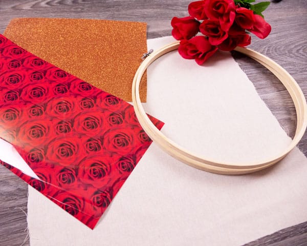 All the supplies needed for the project- ThermoFlex® Fashion Patterns Festive, GlitterFlex® Ultra, a hoop, and cloth.